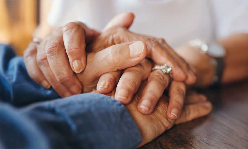 Two men holding hands praying together
